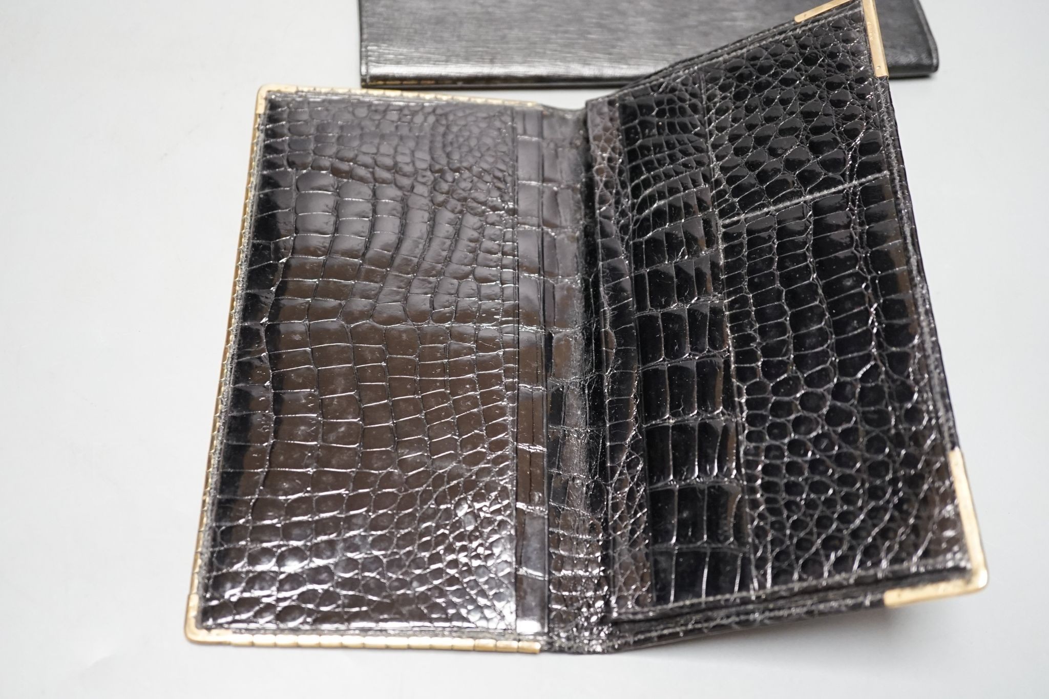 An Alfred Dunhill gold plate mounted leather wallet, 18.9cm, and one other 9ct gold mounted leather wallet initialled J.B.S., 17.9cm.